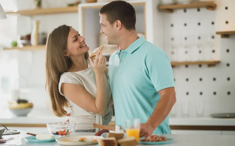 Casal sorrindo na cozinha