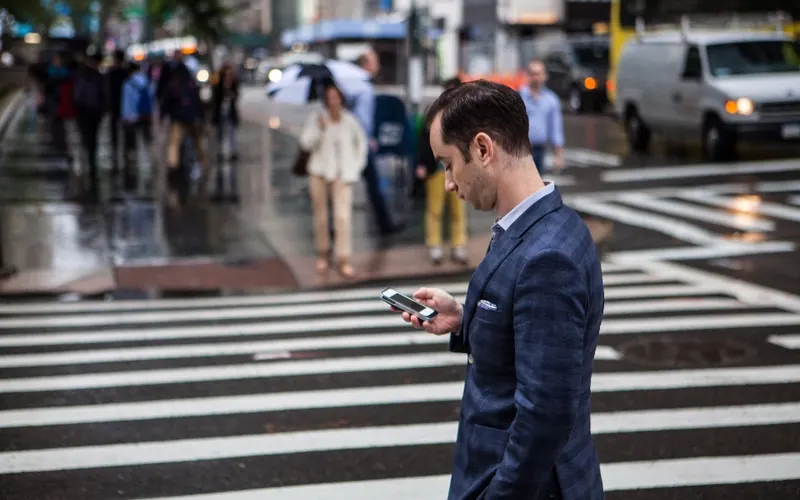 Homem com celular na cidade