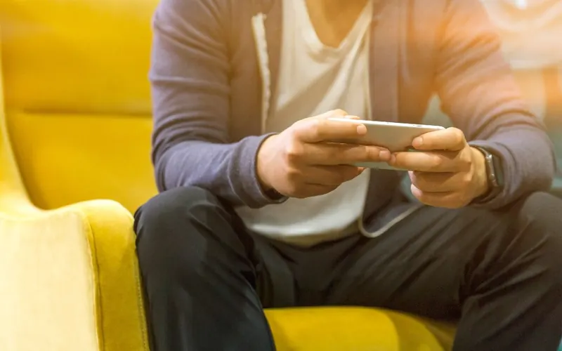 Homem com celular na sala