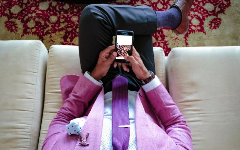 Homem com celular na sala