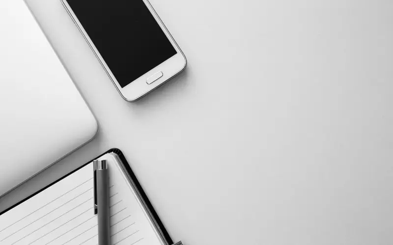 Smartphone sobre um caderno em mesa clara